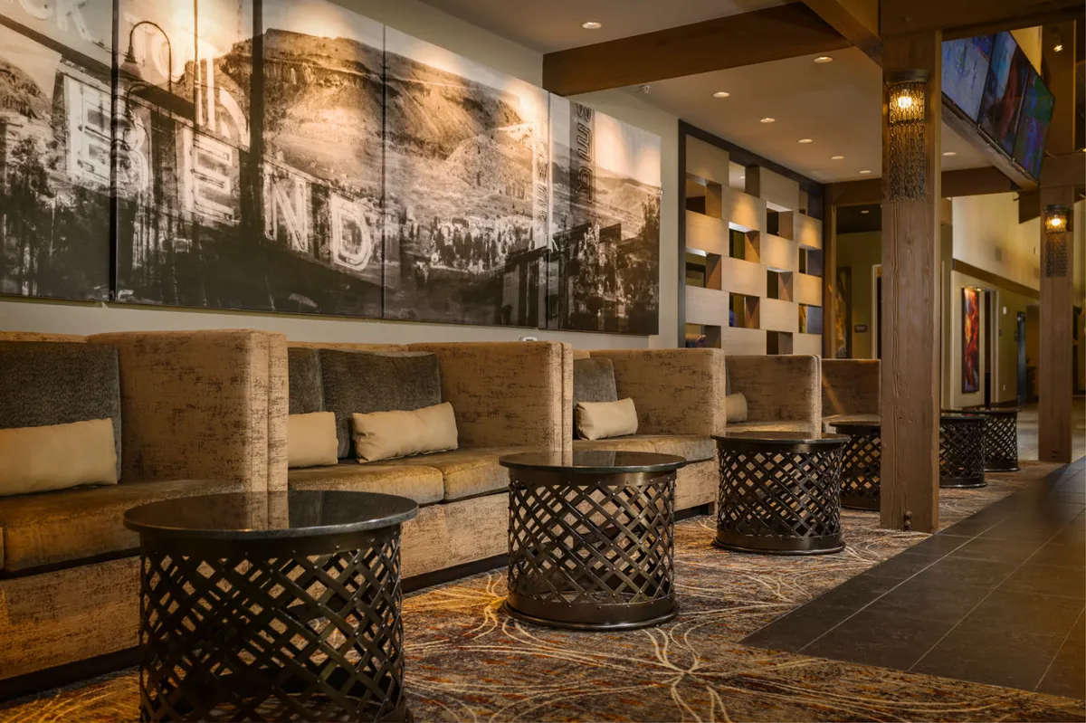 A spacious, inviting lounge area featuring comfortable seating arrangements, large wall art, and decorative tables. The atmosphere is cozy and welcoming, ideal for informal meetings, casual work sessions, or taking a break.